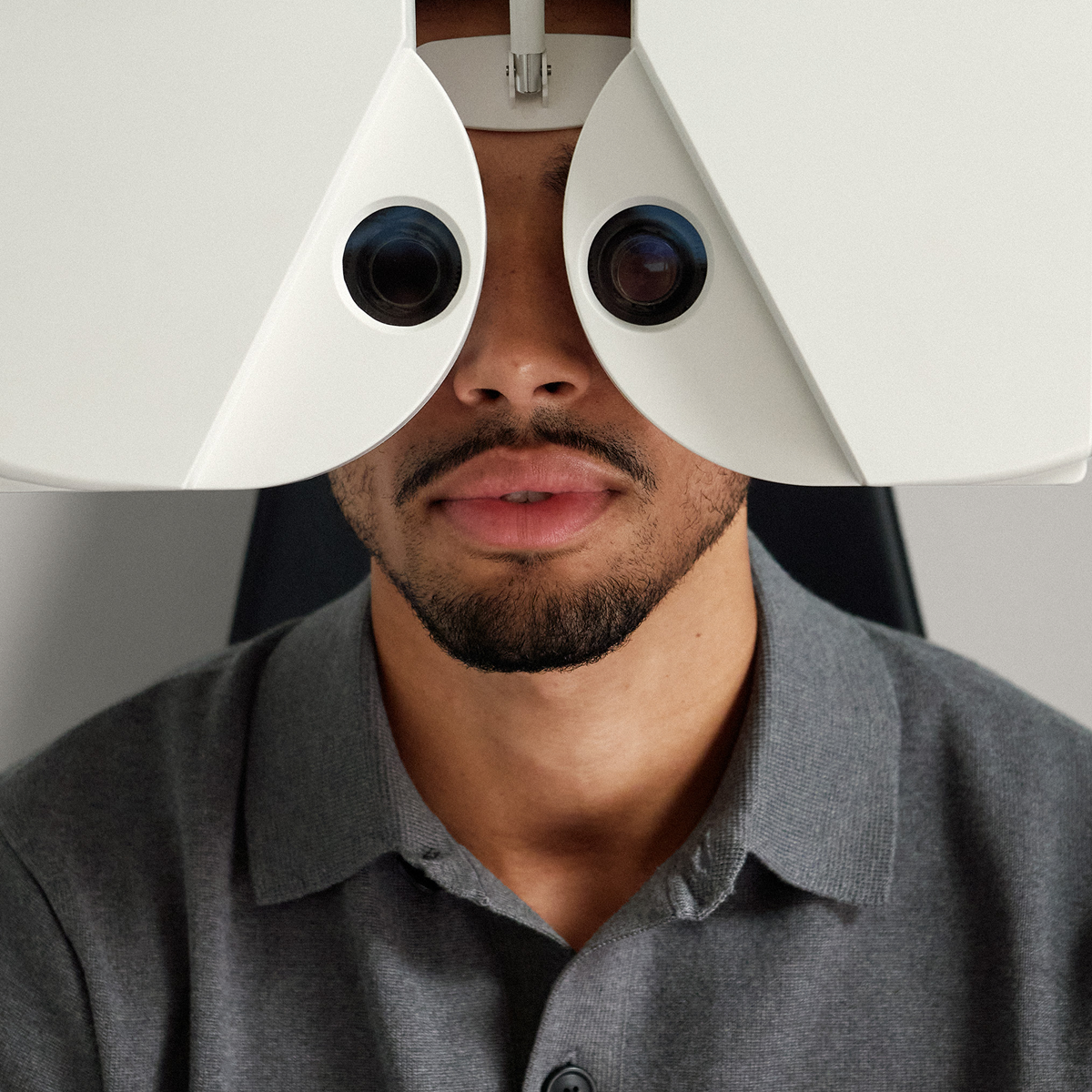 A patient looking into a machine used for a sight test.